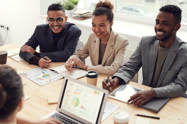 Happy Workers Slowing down at work for maximum productivity and minimal stress, Three People Smiling While Having a Meeting