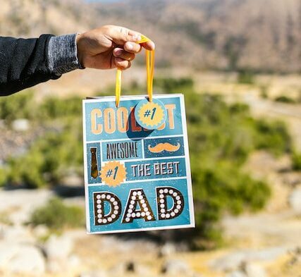 Person carrying a Blue Paper Bag appreciating Father